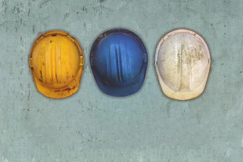 Three old and worn construction helmets Foto stock