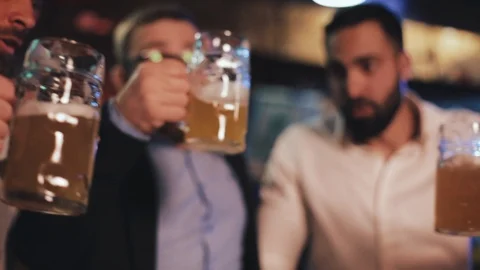 Three old friends clinking their glasses with beer in pub. Close up, slow motion Stock Footage 109595978