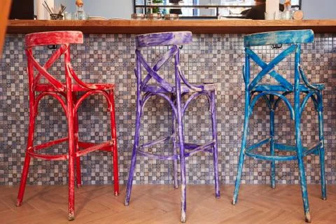 Three old multi-colored chairs standing in a row near the bar Stockfoto's