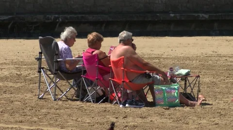 Three old people sitting on deck chairs Stock Footage 51749074