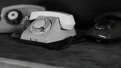 Three old phones on the table black and white Stock Footage 114351578