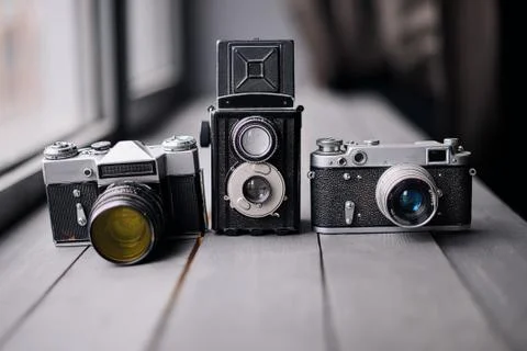 Three Old Reflex Cameras Isolated On Wooden Background vintage twin Lens refl Stock Photos