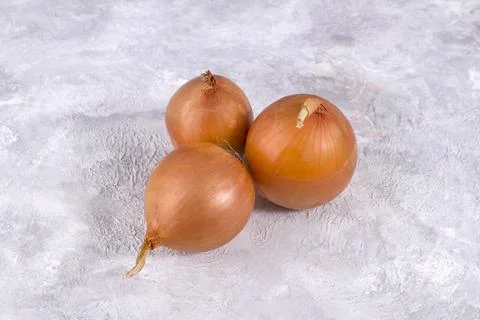 Three onions on a light background Stock Photos
