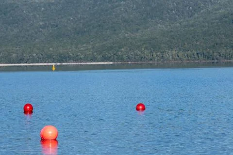 Three orange buoys in triangle pattern in surface Lake Te Anau Stock Photos
