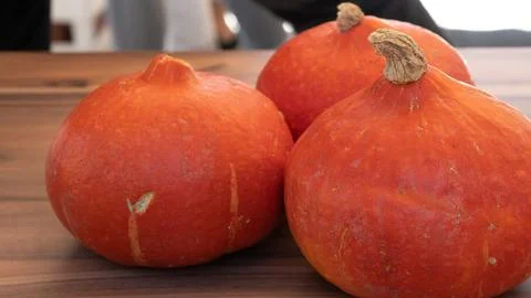 Three orange pumpkins on the table close-up Stock Photos