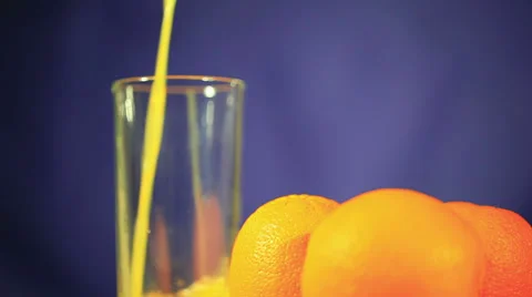 Three oranges and  juice which is pouring in  glass Vidéo 29163239