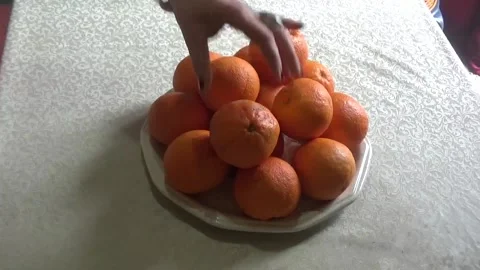 Three oranges are placed on top of the orange pyramid Stock Footage 307383979