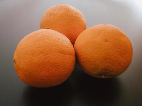 Three Oranges In Black Background Stock Photos