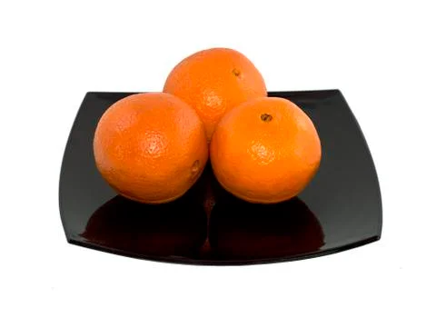 Three oranges on a black plate Foto stock
