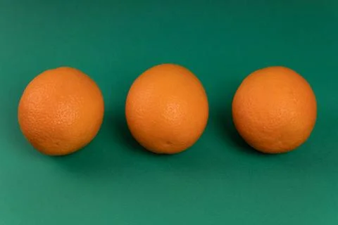 Three oranges on a green background Stock Photos