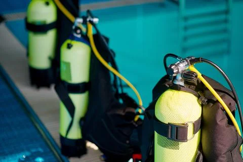 Three oxygen tanks at poolside, diving equipment Stock Photos