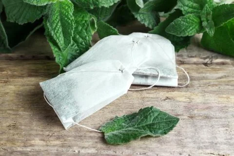 Three packets of tea on a mint background on a wooden background Stock Photos