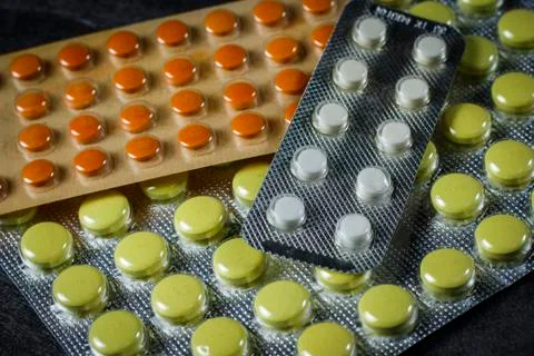 Three packs of tablets on a dark table Stock Photos