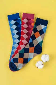 Three pair of colored socks with rhombuses on Yellow background Foto stock