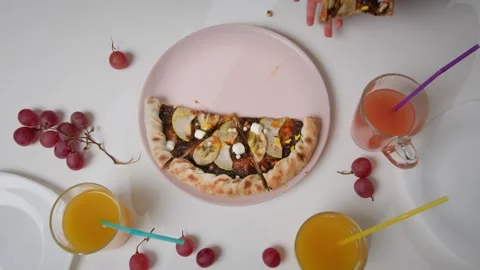 Three pairs of children's hands take pieces of chocolate pizza from a pink plate Video stock 259826585