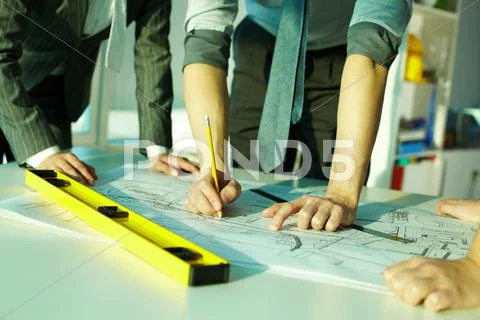 Three pairs of hands sketching a housing project Stock Photos