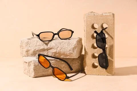 Three pairs of sunglasses on beige bricks Stock Photos