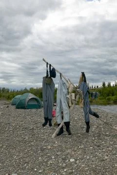 Three pairs of waders drying on a river bank Stock Photos