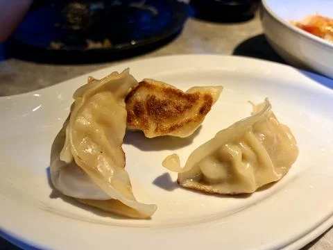Three Pan-Fried Dumplings on White Plate Stock Photos
