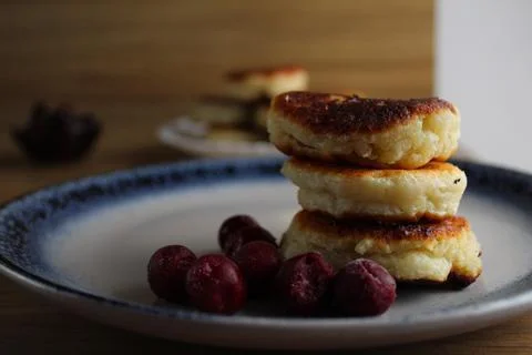 Three pancake cheesecakes lie a stack of slides on top of each other on a pla Stock Photos