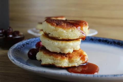 Three pancake cheesecakes lie a stack of slides on top of each other on a pla Stock Photos