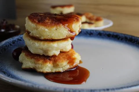 Three pancake cheesecakes lie a stack of slides on top of each other on a pla Stock Photos
