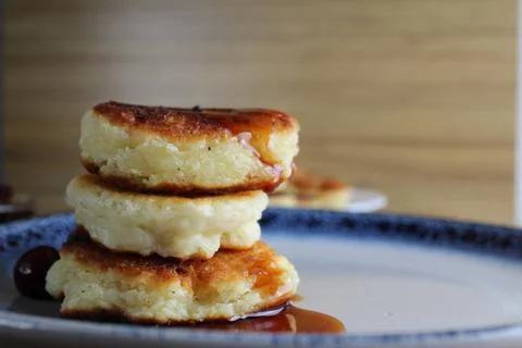Three pancake cheesecakes lie a stack of slides on top of each other on a pla Stock Photos