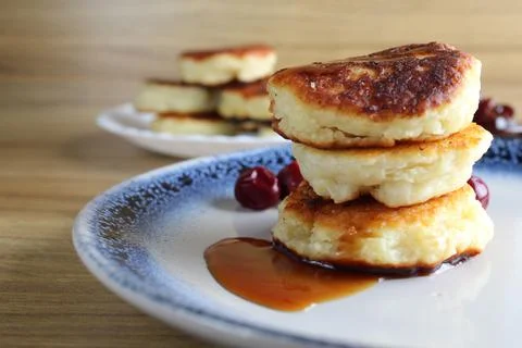Three pancake cheesecakes lie a stack of slides on top of each other on a pla Stock Photos
