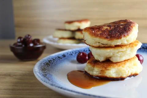 Three pancake cheesecakes lie a stack of slides on top of each other on a pla Stock Photos