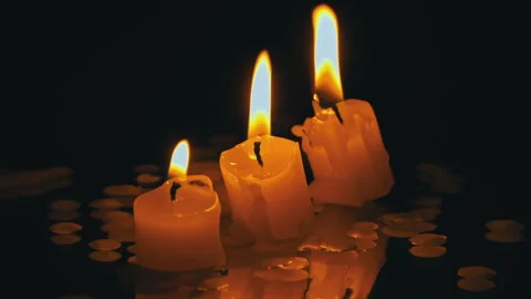 Three Paraffin Candles Burn in a Row on a Black Background with Reflection Stock Footage 264757573