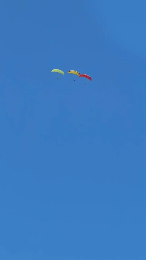 Three paragliders flying in formation across the blue sky above Montenegro Stock Footage 314002440