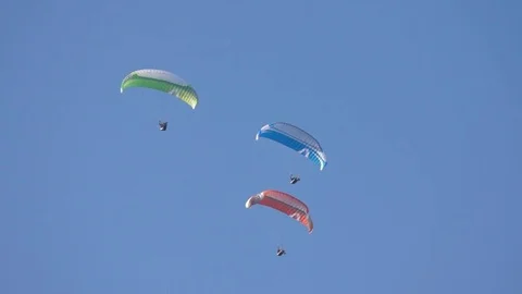 Three paragliders sailing in the blue sky Stock Footage 76005568