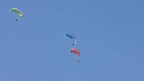 Three paragliders sailing in the blue sky Stock Footage 76005581