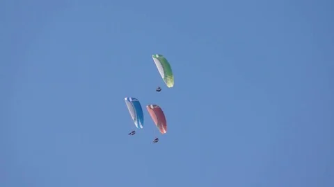 Three paragliders sailing in the clear sky Stock Footage 76005560