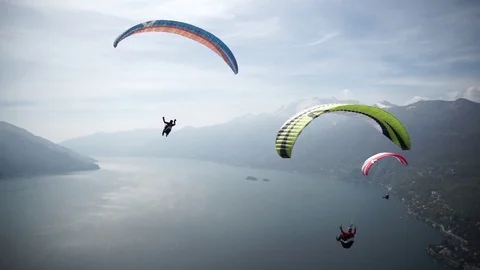 Three paragliders sailing over the river during winter Stock Footage 76004100