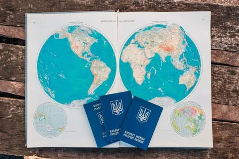 Three passports on the background of the world map. The journey begins. Stock-Fotos