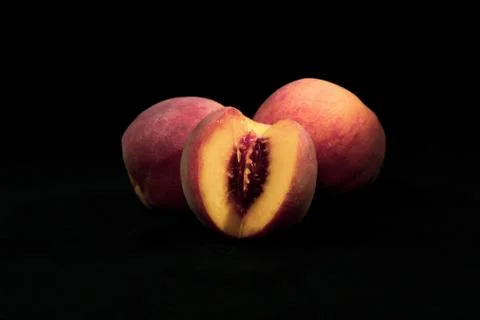 Three peaches on a black background Stock Photos
