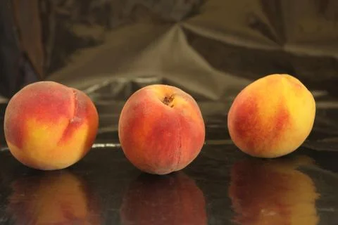 Three peaches on a black background Stock-Fotos