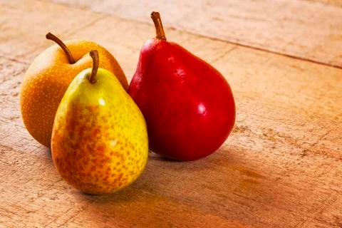 Three pears on a rustic wood surface Stock Photos