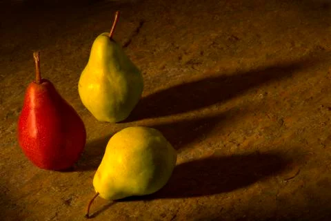 Three Pears on a Table with Shadows Stock Photos