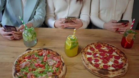 Three people are sitting at a table with pizzas Stock Footage 270220482