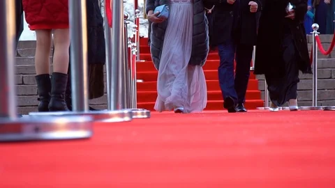 Three people are walking on the red carpet, low angle close up Stock Footage