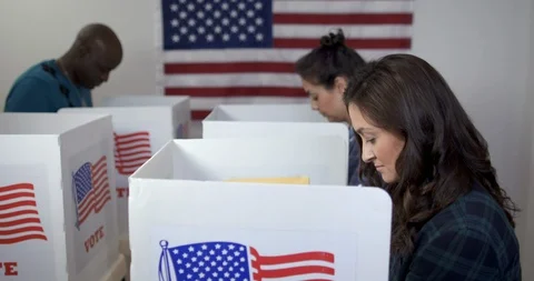 Three people casting votes in booths at polling station 4K Stock Footage 114929530