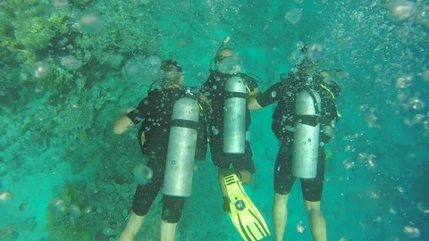 Three people diving in the sea Stock Footage 121382965