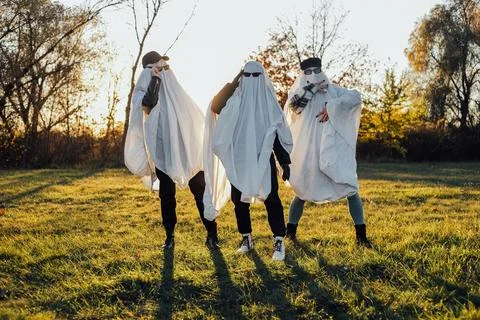 Three people in ghost costumes standing outdoors Stock Photos