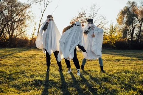 Three people in ghost costumes standing outdoors Stock Photos