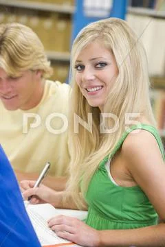 Three people in library studying (selective focus) Stock Photos