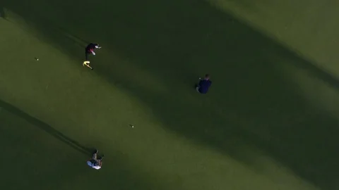 Three people playing golf on a golf course 動画素材 76236488