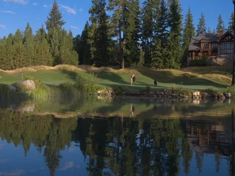 Three people playing golf by a lake Stock-Footage 76236481