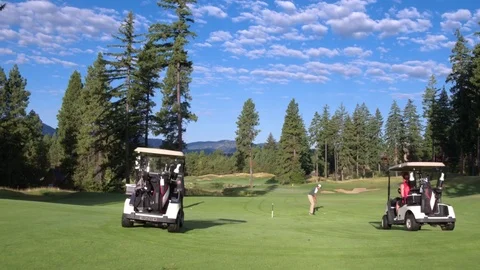 Three people playing golf by a lake 動画素材 76236508